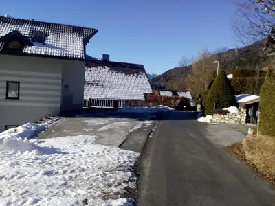 a house with snow on the driveway at JULIJA 3 SUNNY APPARTMENT in Kranjska Gora