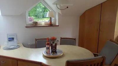 a dining room table with two bottles of wine at JULIJA 3 SUNNY APPARTMENT in Kranjska Gora