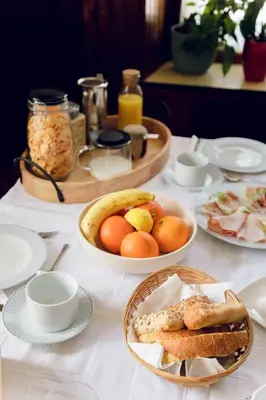 a table with plates of food and fruit on it at Ana Antloga Apartments in Bled