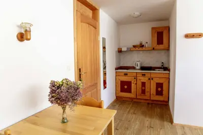 a kitchen with a table with a vase of flowers on it at Ana Antloga Apartments in Bled