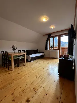 a living room with a table and a bed at Ana Antloga Apartments in Bled