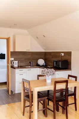 a kitchen with a wooden table and some chairs at Ana Antloga Apartments in Bled