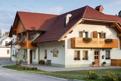 a large white house with a red roof at Penzion Kaps in Bled