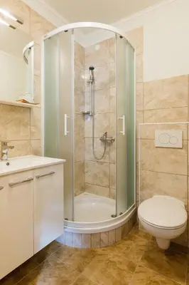 a bathroom with a shower and a toilet and a sink at Penzion Kaps in Bled