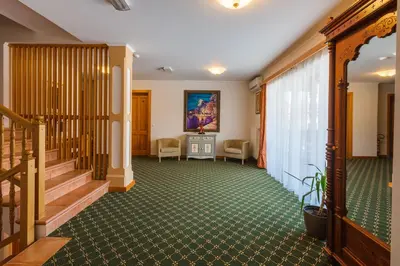a hallway with a staircase and a room with a table at Penzion Kaps in Bled