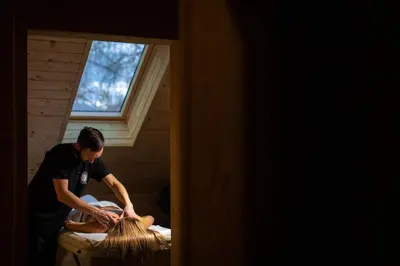 a man cutting a persons lap with a brush at Kozjanski dvor in Podčetrtek