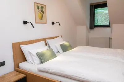 a bedroom with a large white bed with two pillows at Kozjanski dvor in Podčetrtek