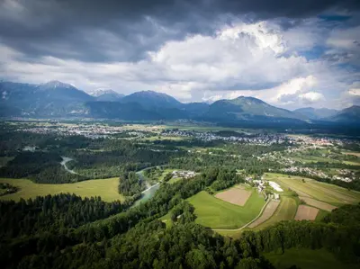 an aerial view of a town in a valley with mountains at PUŽMAN Farm Glamping in Radovljica