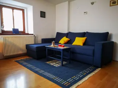 a living room with a blue couch and a table at Kranjska Gora Family Break in Kranjska Gora