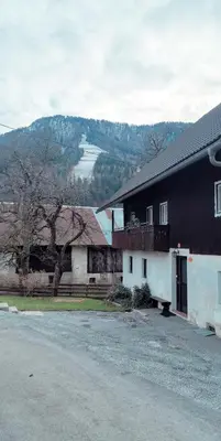 a black and white building with a tree and a house at Kranjska Gora Family Break in Kranjska Gora