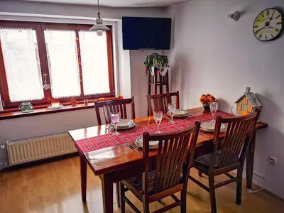 a dining room with a table and chairs and a clock at Kranjska Gora Family Break in Kranjska Gora