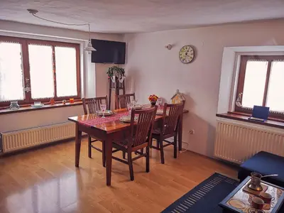 a dining room with a table and chairs and a clock at Kranjska Gora Family Break in Kranjska Gora