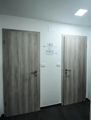 two wooden doors in a room with a sign on the wall at Rooms pr zajčku in Tolmin