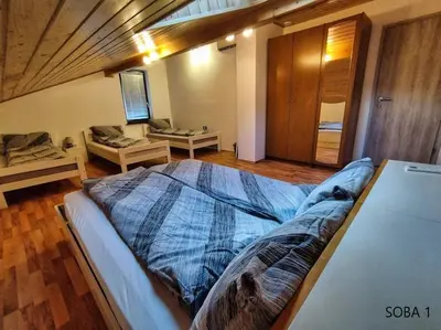 a bedroom with a large bed and a couch at Rooms pr zajčku in Tolmin
