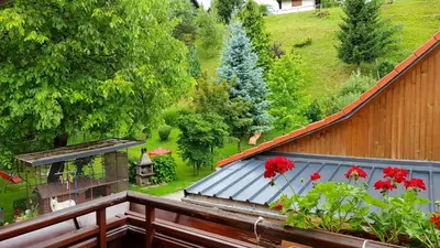a balcony with a roof with red flowers on it at APARTMA SVETINA in Bled