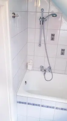 a bathroom with a shower with a white tub at APARTMA SVETINA in Bled