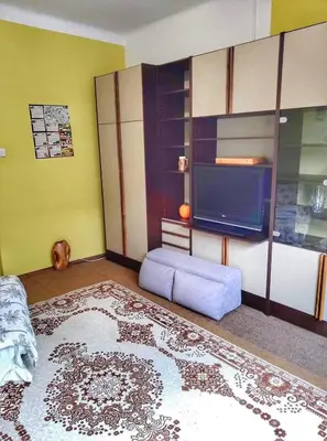 a living room with a tv and a blue couch at Apartma Vita in Rečica ob Savinji