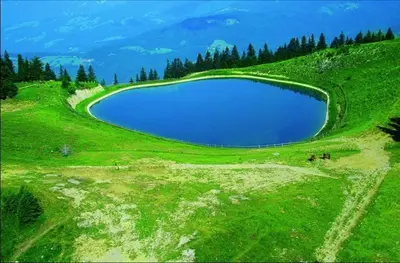 a large pool of water on a green field at Apartma Vita in Rečica ob Savinji