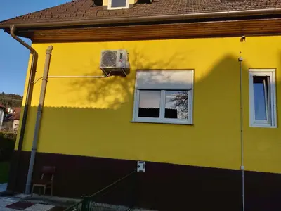 a yellow and green house with a window at Apartma Vita in Rečica ob Savinji