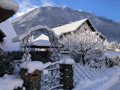 a fence covered in snow in front of a house at SavaDolinka House ID 116O7O in Mojstrana
