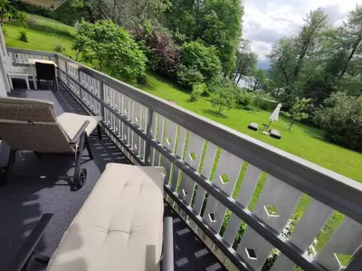 a balcony with white furniture and a view of the water at Lake House Sebanc in Bled