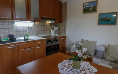 a kitchen with wooden cabinets and a wooden table at Lake House Sebanc in Bled