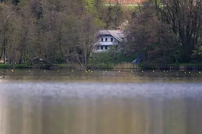 a house sitting on the side of a lake at Lake House Sebanc in Bled