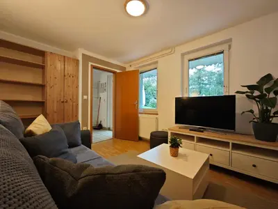 a living room with a couch and a flat screen tv at Lake House Sebanc in Bled