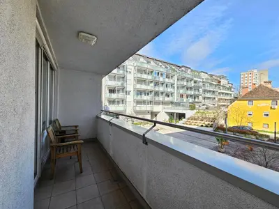 a balcony with a chair and a view of a building at Apartment Irena Tour As Ljubljana in Ljubljana
