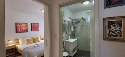 a bedroom with a bed and a bathroom with a shower at Apartment Irena Tour As Ljubljana in Ljubljana