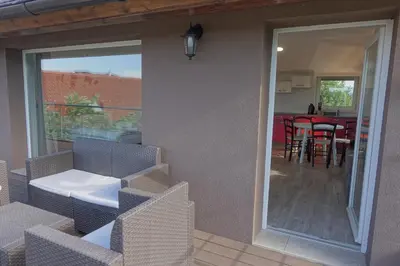 a patio with chairs and a table and a dining room at Apartments Laura FARM STAY in Podčetrtek