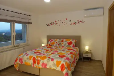 a bedroom with a bed with flowers on the wall at Apartments Laura FARM STAY in Podčetrtek