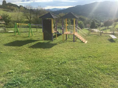 a playground in a field of grass with a slide at Apartments Laura FARM STAY in Podčetrtek
