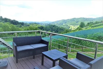 a balcony with two chairs and a table and a view at Apartments Laura FARM STAY in Podčetrtek