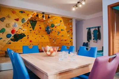 a dining room with a table and a climbing wall at Apartment Kapitan with climbing wall in Kobarid