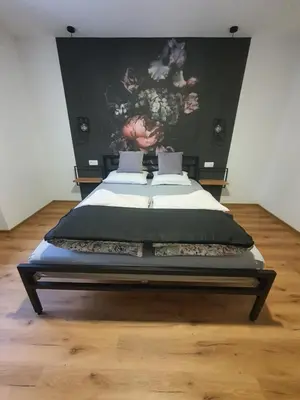 a bedroom with a bed with a painting on the wall at Apartment Šelih in Maribor