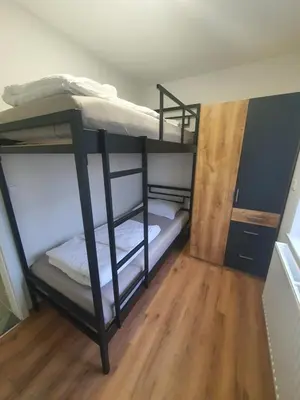 a room with two bunk beds and a wooden floor at Apartment Šelih in Maribor
