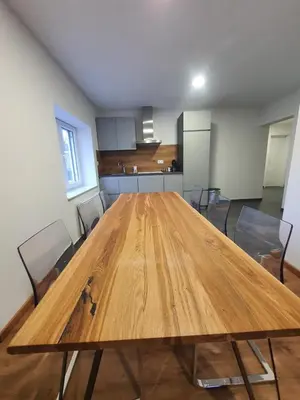 a large wooden table in an empty room with chairs at Apartment Šelih in Maribor