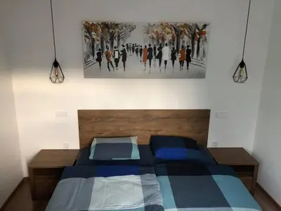 a bedroom with a bed and a painting on the wall at Apartment Šelih in Maribor