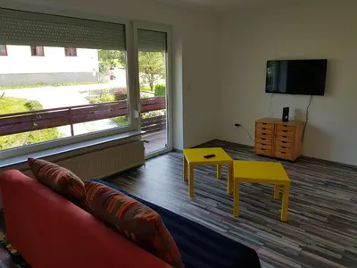 a living room with a couch and a table and a tv at Apartma Unica in Bled