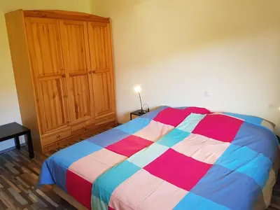 a bedroom with a colorful bed and a wooden cabinet at Apartma Unica in Bled