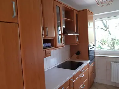 a kitchen with wooden cabinets and a sink and a window at Apartma Unica in Bled