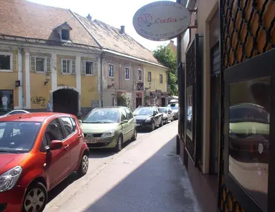 a row of cars parked on a street with buildings at Rimska Apartments Tour As Ljubljana in Ljubljana
