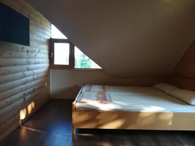 a bed in a room with a window at Brunarica Lorentia in Bizeljsko