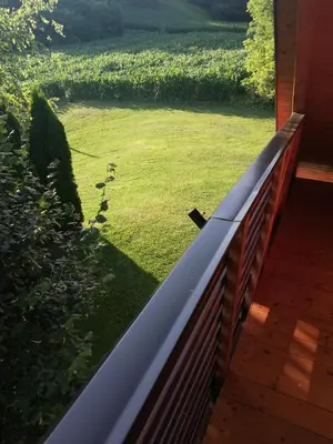 a porch with a fence and a field of grass at Brunarica Lorentia in Bizeljsko