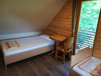 a small room with a bed and a table at Brunarica Lorentia in Bizeljsko