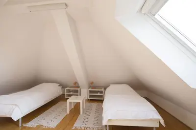 two beds in a attic room with a window at Spacious 2-bedroom apartment Zabjak with AC Tour As Ljubljana in Ljubljana