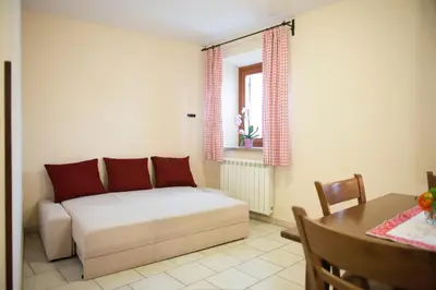a living room with a bed and a table at Guesthouse Muha in Lipica