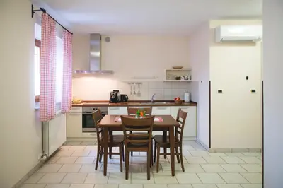 a kitchen with a table and chairs in it at Guesthouse Muha in Lipica