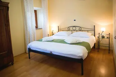 a bedroom with a large bed with white sheets and pillows at Guesthouse Muha in Lipica